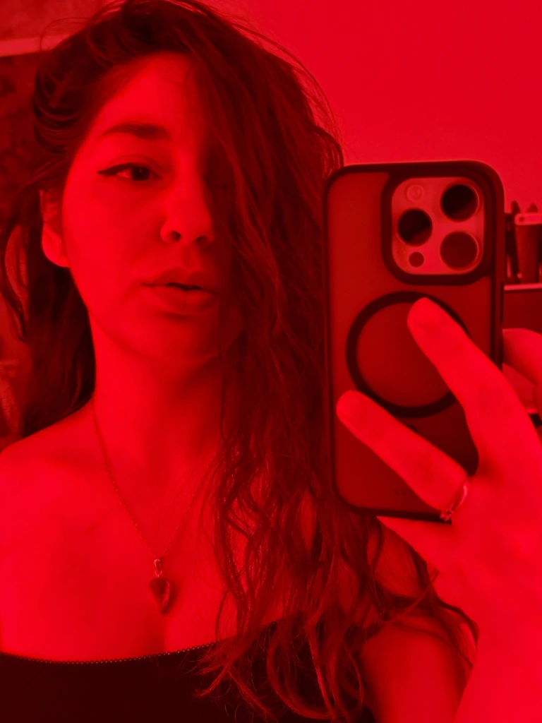 Štěpánka Pluhařová, autorka abstraktního umění a zakladatelka PLUHART, na portrétní fotografii v červeném světle.